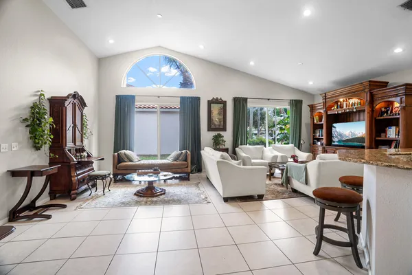 a living room with furniture a flat screen tv and a large window