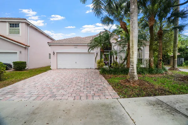 a front view of a house with a yard and a garage