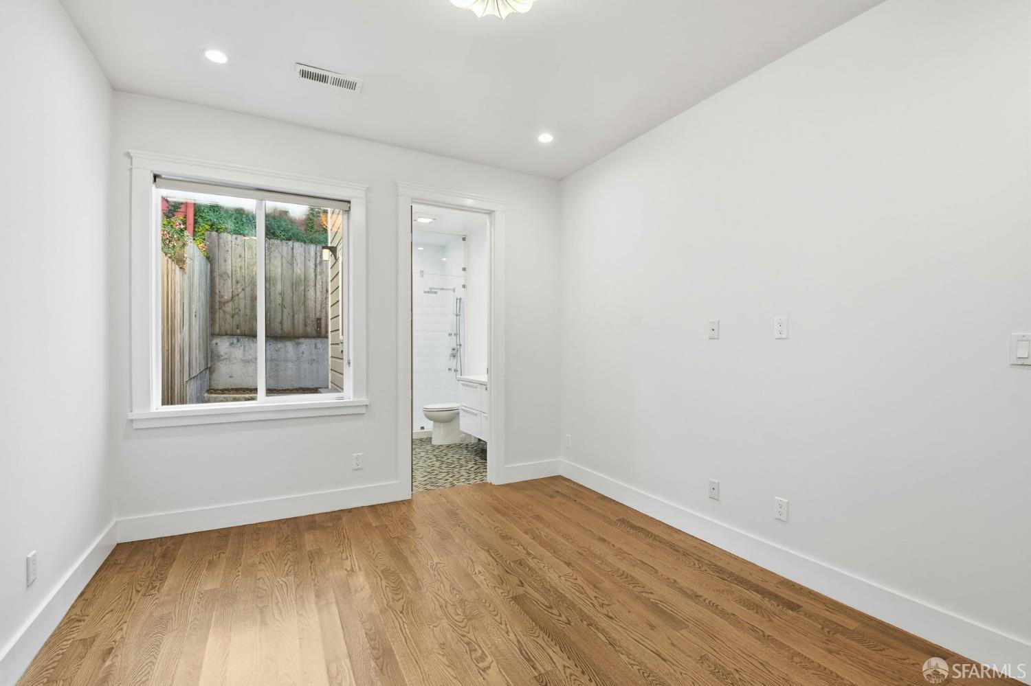 526 Silver Avenue San Francisco, CA 94112 - Photo 31 of 44 an empty room with wooden floor and a window