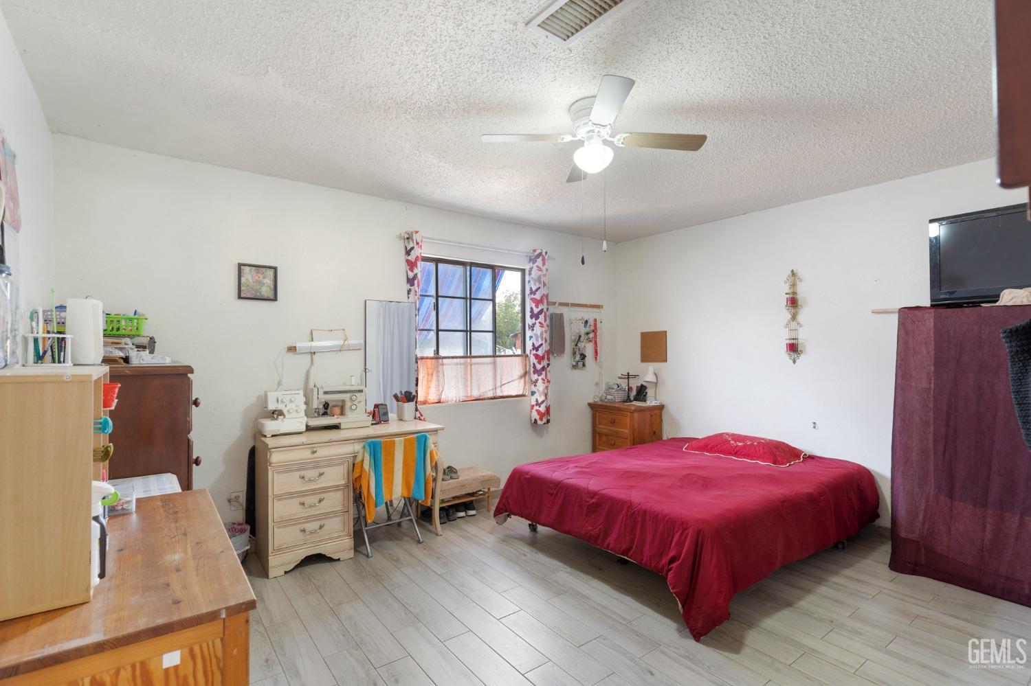 Undisclosed Address Arvin, CA 93203 - Photo 11 of 19 a spacious bedroom with a bed and a bookshelf