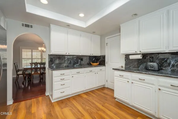 a kitchen with granite countertop white cabinets and white appliances