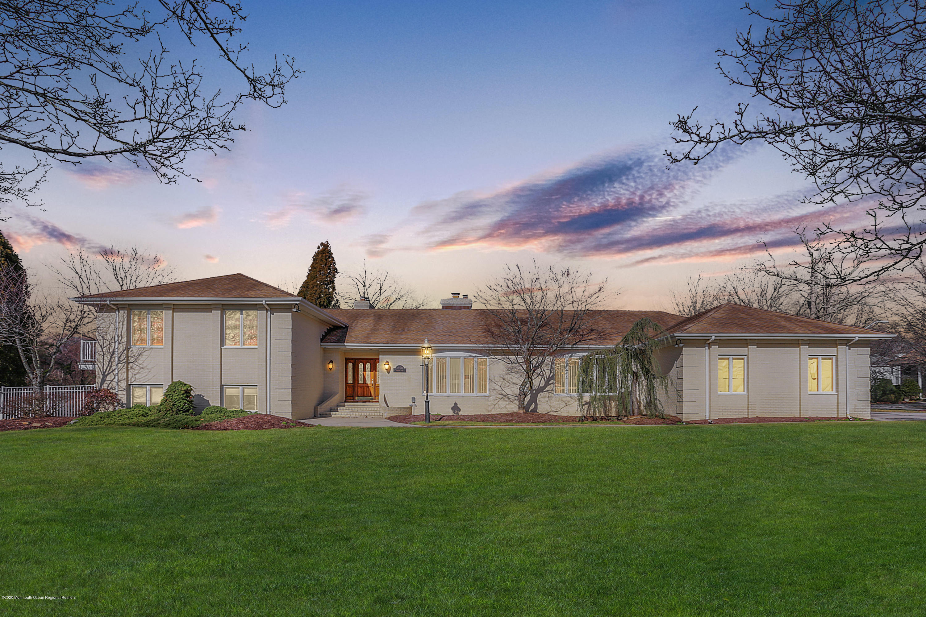 a view of a house with a big yard and large trees