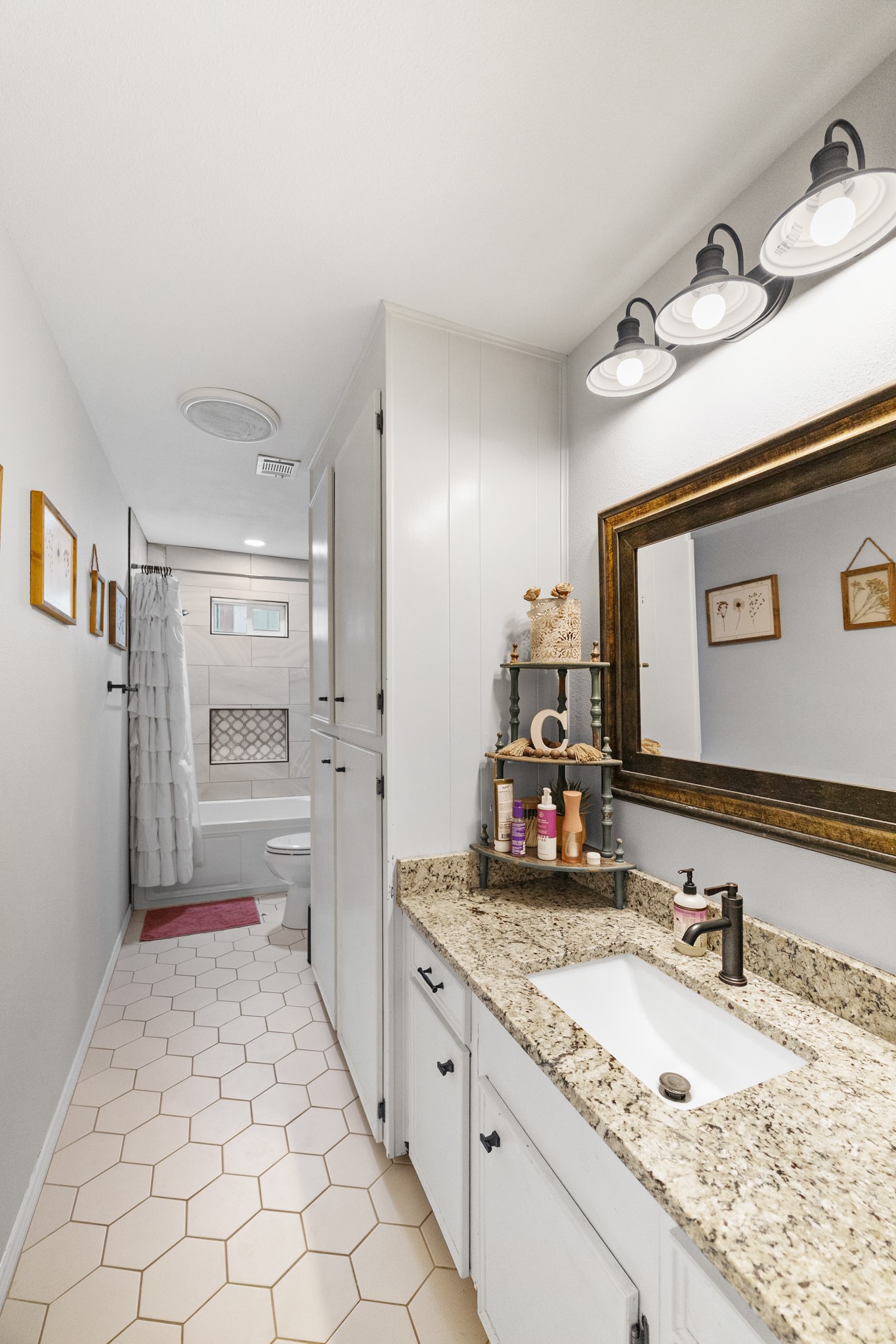 1003 Virginia Street Edna, TX 77957 - Photo 18 of 30 a bathroom with a granite countertop sink and a mirror