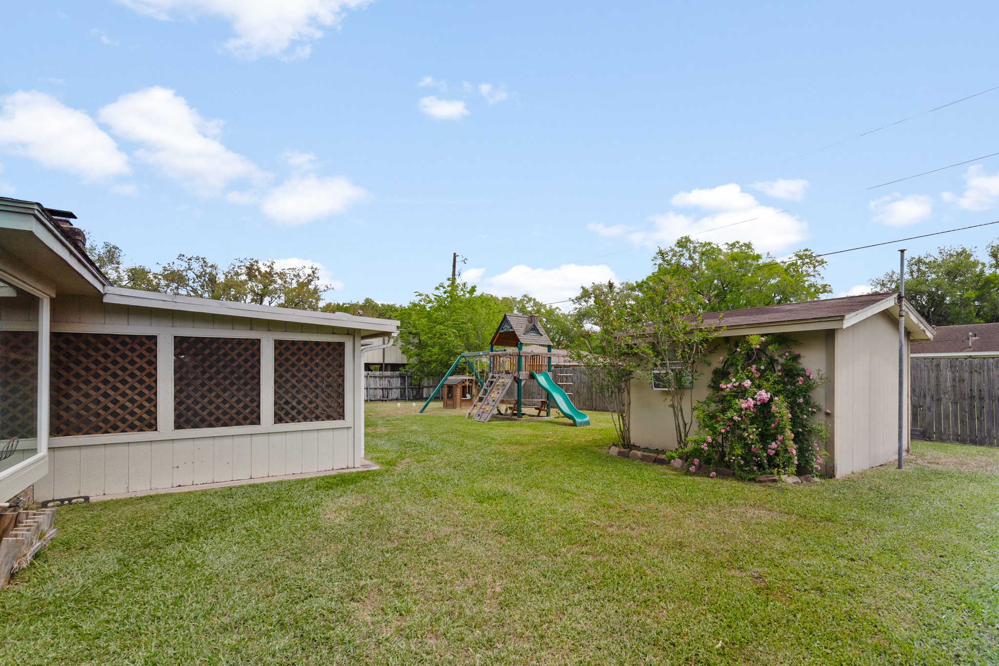 1003 Virginia Street Edna, TX 77957 - Photo 26 of 30 a view of a backyard with potted plants and a large tree