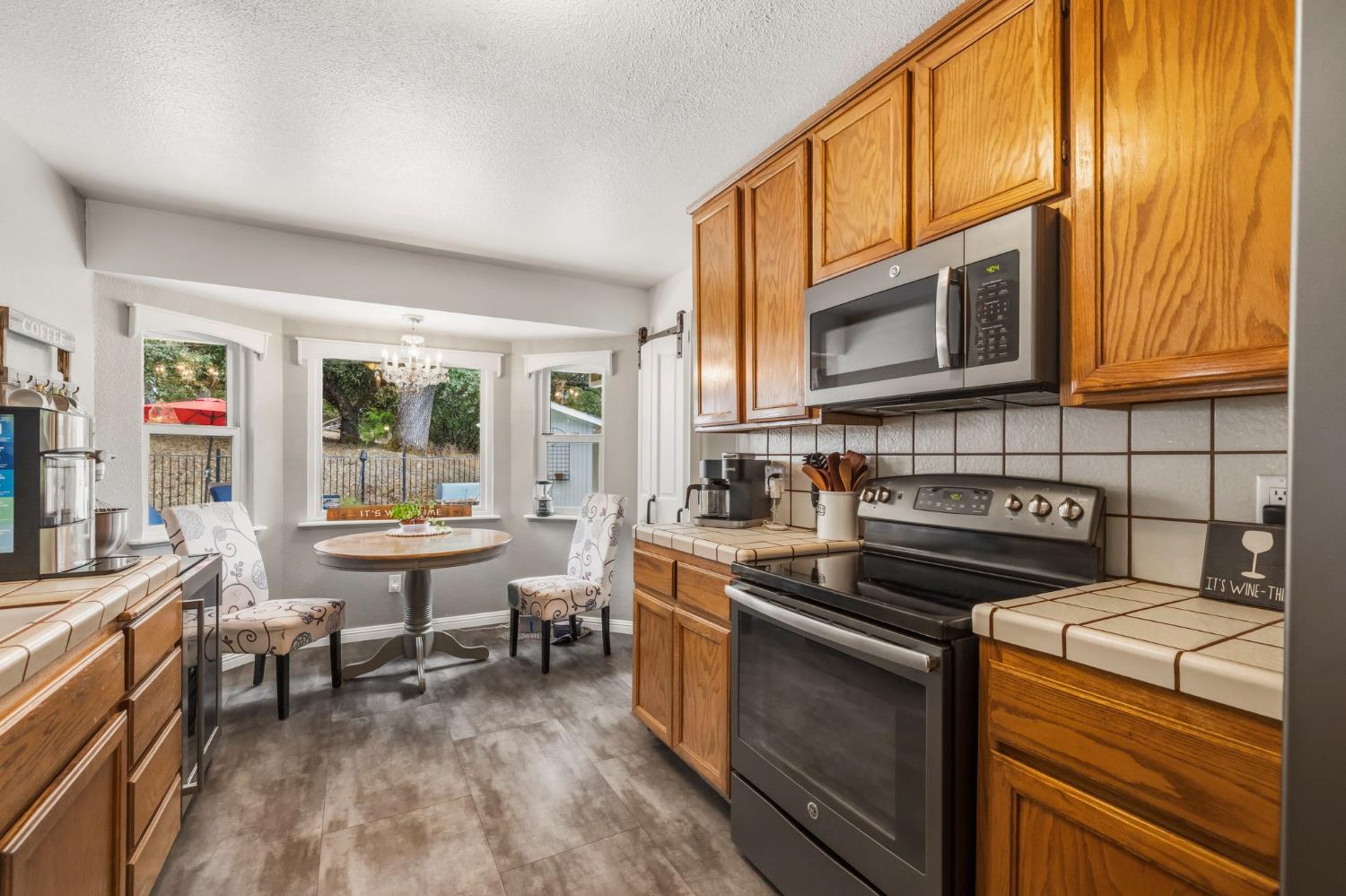 11460 Racetrack Road Sonora, CA 95370 - Photo 11 of 46 a kitchen with a stove a sink and wooden cabinets