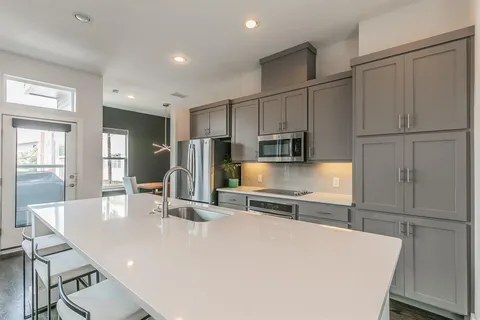 a kitchen with stainless steel appliances a refrigerator and microwave