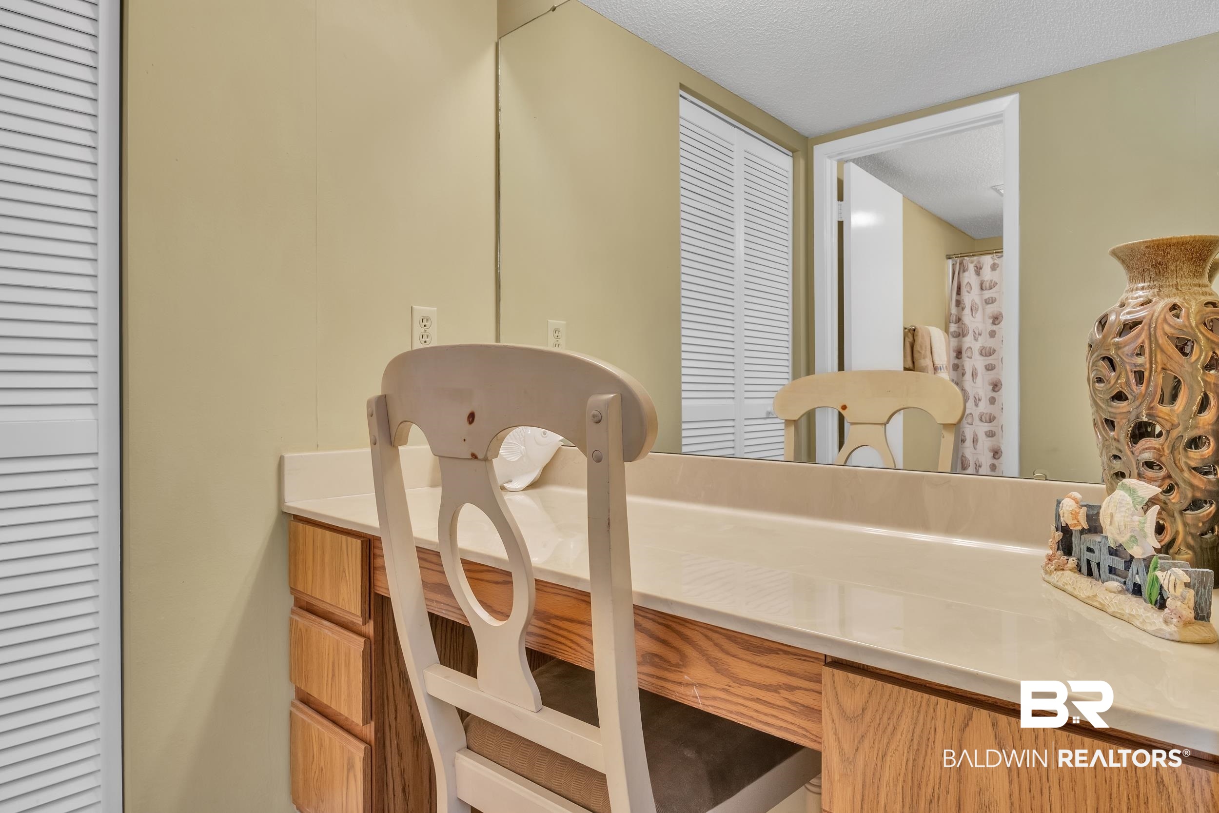 3256 Loop Road, Unit 2 Orange Beach, AL 36561 - Photo 24 of 25 Vanity area featuring a spacious countertop, wood-finish cabinetry, and an integrated mirror