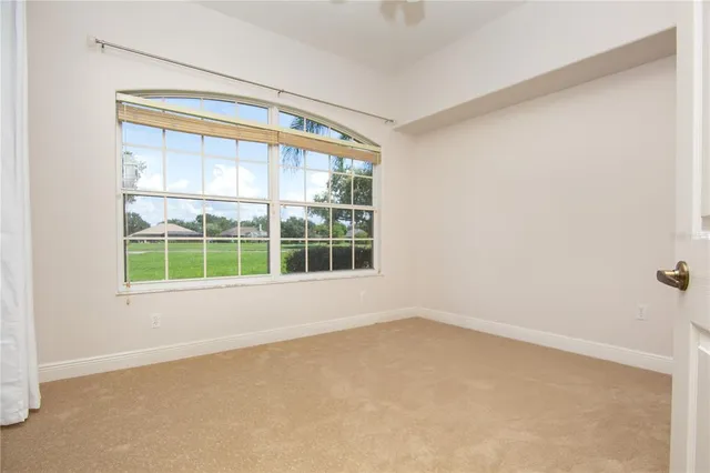 a view of an empty room with a fireplace and windows