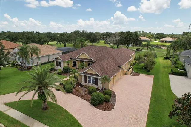 a front view of a house with a yard and potted plants