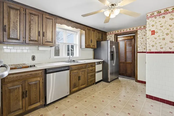 a kitchen with stainless steel appliances kitchen island granite countertop a refrigerator and a sink