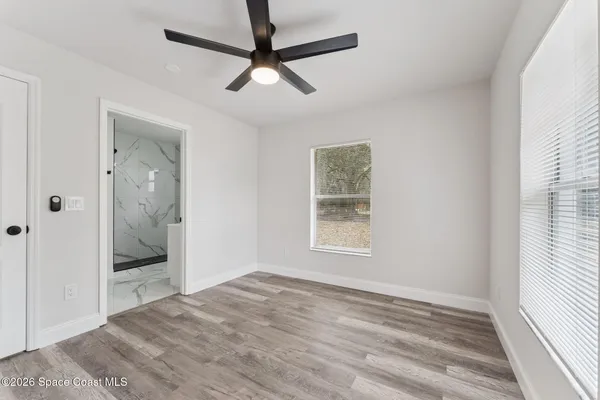 an empty room with fan and windows