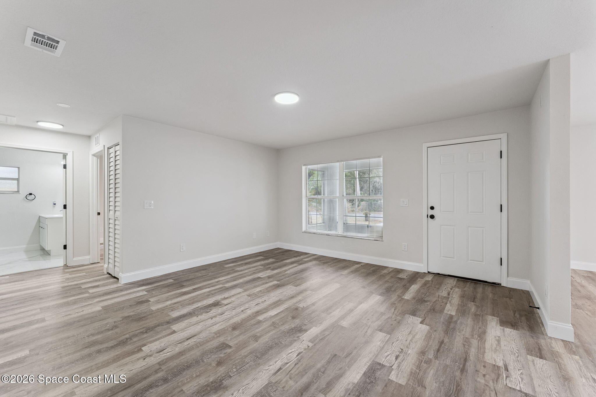 2665 Myrtle Avenue Mims, FL 32754 - Photo 3 of 23 a view of an empty room with wooden floor and a window