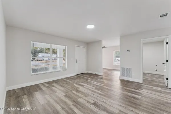 a view of empty room with wooden floor