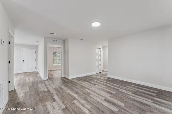 a view of empty room with wooden floor