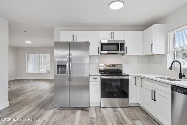 a kitchen with stainless steel appliances granite countertop a stove a sink and a refrigerator