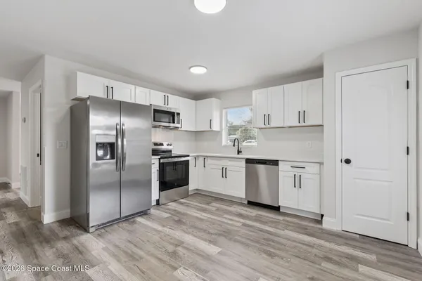 a kitchen with granite countertop stainless steel appliances a refrigerator and a sink