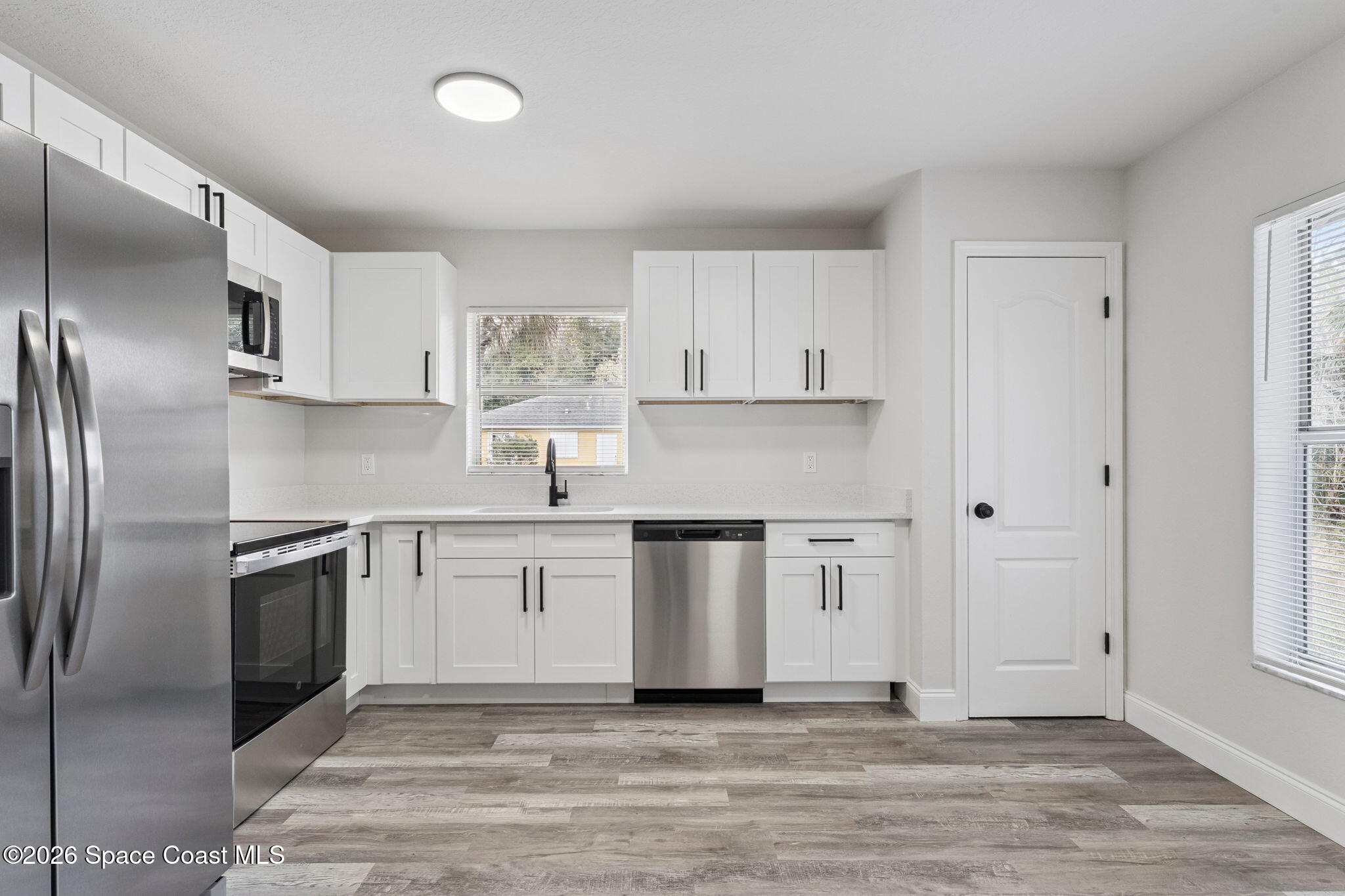 2665 Myrtle Avenue Mims, FL 32754 - Photo 8 of 23 a kitchen with granite countertop a refrigerator stove top oven and sink