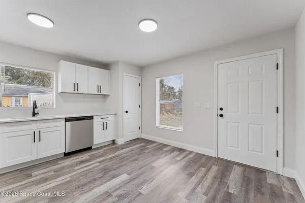 a kitchen with granite countertop white cabinets and white appliances