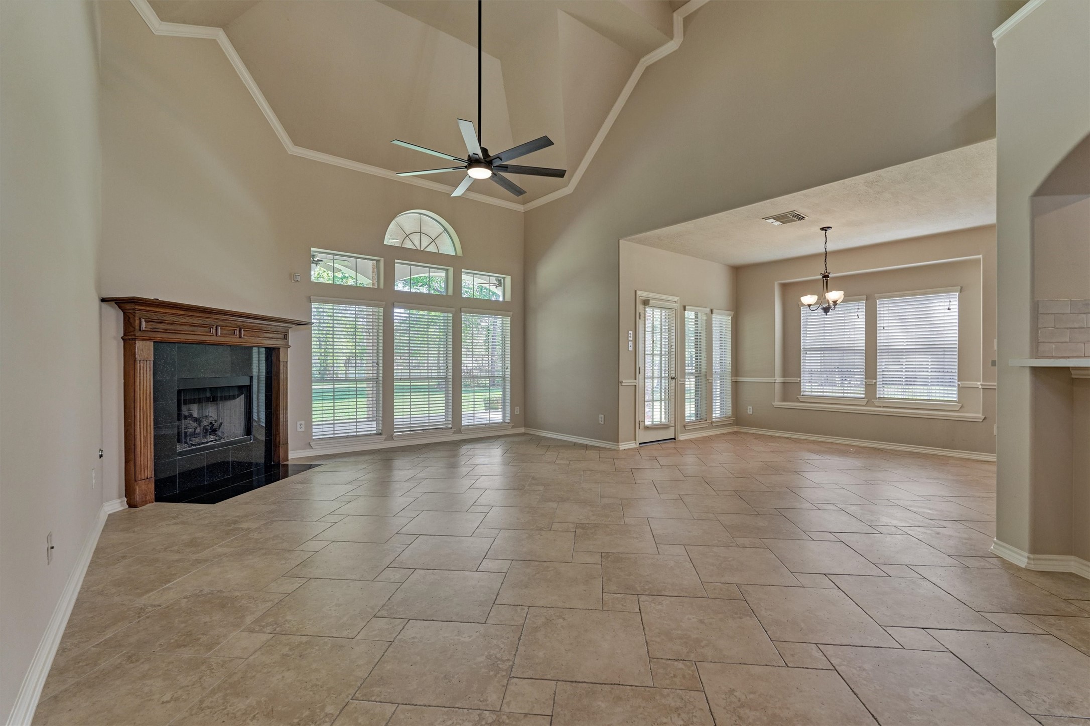 30202 West Legends Trail Drive Spring, TX 77386 - Photo 15 of 50 The family room is a large space with soaring ceilings, fresh neutral paint, gorgeous travertine flooring and a large corner gas fireplace. This is a lovely room with expansive views to the backyard.