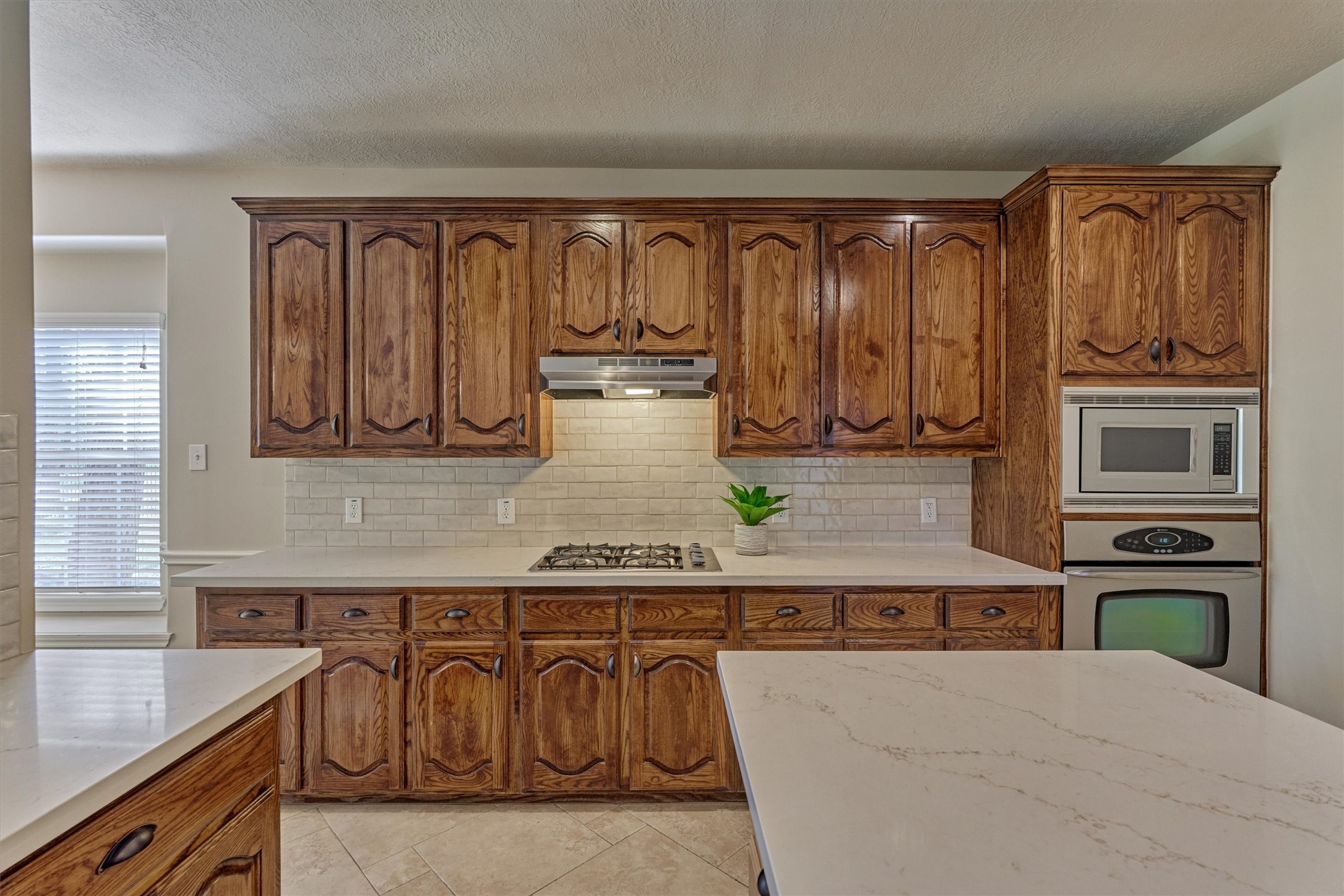 30202 West Legends Trail Drive Spring, TX 77386 - Photo 22 of 50 The kitchen has beautiful, stained cabinets, a gas cooktop, new Quartz counters and tile backsplash and all stainless-steel appliances.