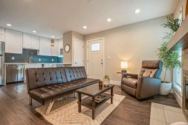 a living room with furniture kitchen view and a potted plant