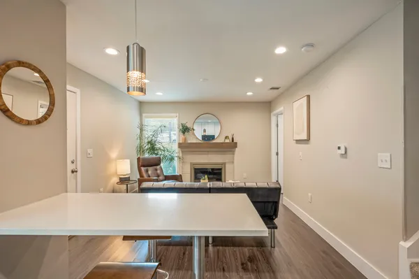 a living room with table chairs and fireplace