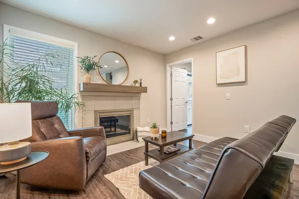 a kitchen with stainless steel appliances kitchen island granite countertop a refrigerator a stove and a sink with wooden floor