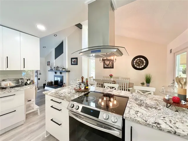 a large kitchen with kitchen island a large counter space appliances and a chandelier