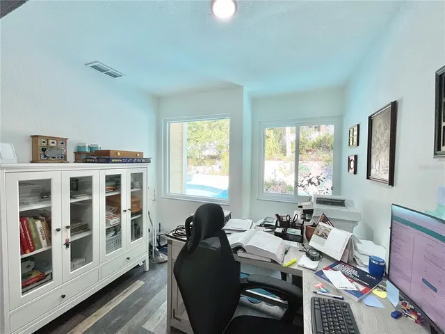 a room with painting on the wall and a potted plant