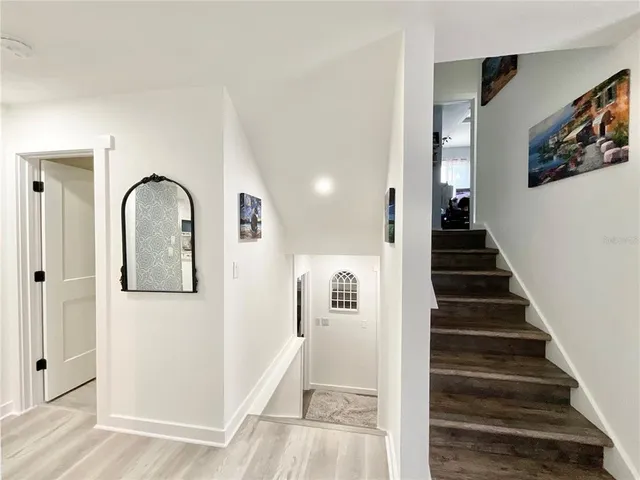 a view of a hallway with wooden floor and staircase