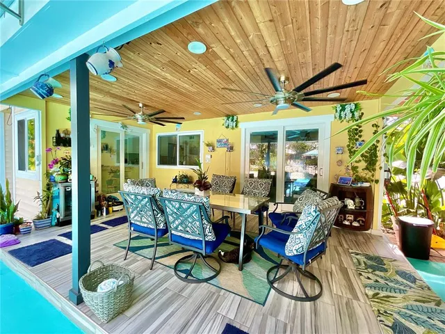 a view of a white house with a big yard and potted plants