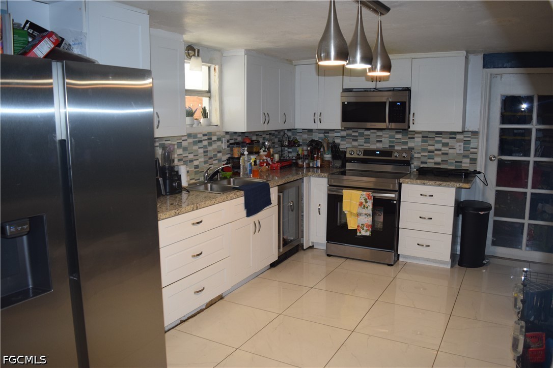 17 Colorado Road Lehigh Acres, FL 33936 - Photo 7 of 17 a kitchen with stainless steel appliances a stove sink and refrigerator
