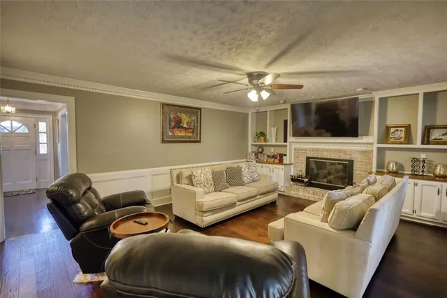 a living room with furniture a flat screen tv and a fireplace