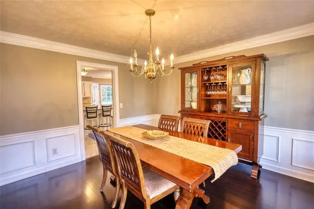 a dining room with furniture a chandelier and wooden floor