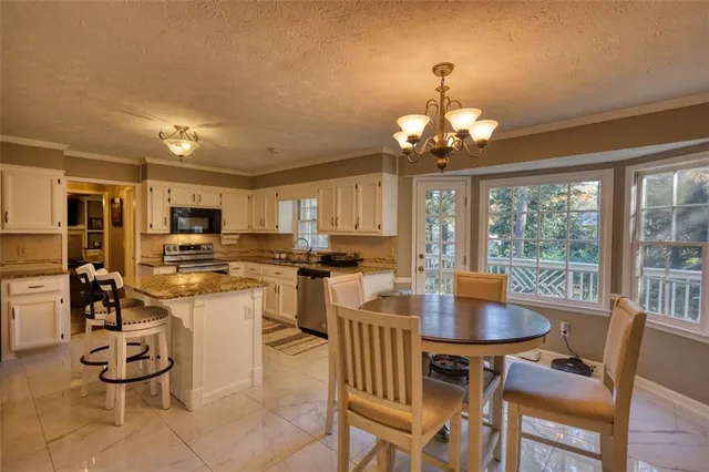 a kitchen with granite countertop a stove microwave and sink