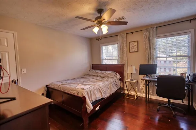 a bedroom with a bed and a chandelier fan