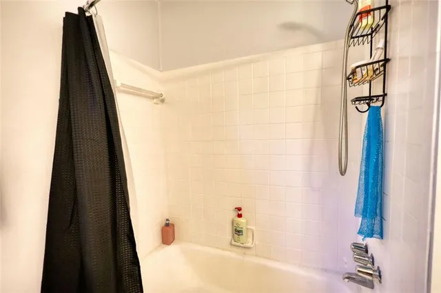 a bathroom with a granite countertop sink and a bathtub