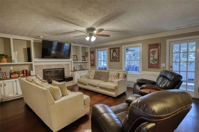 a living room with furniture a flat screen tv and a fireplace