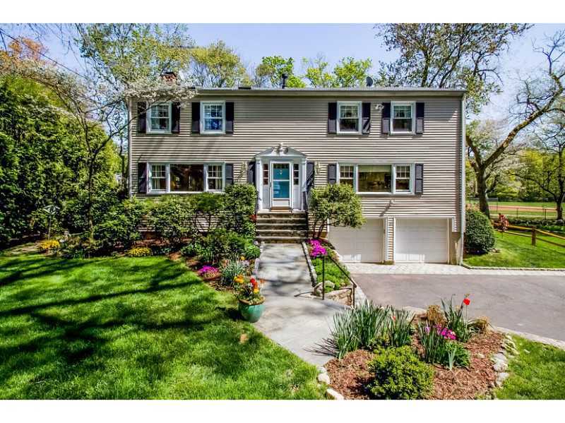 a front view of a house with a yard and potted plants