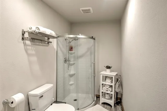 a bathroom with a shower a toilet and a sink
