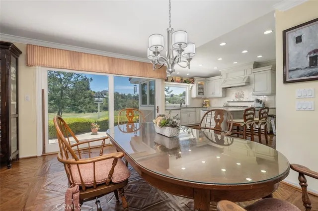 a dining room with furniture a chandelier and wooden floor