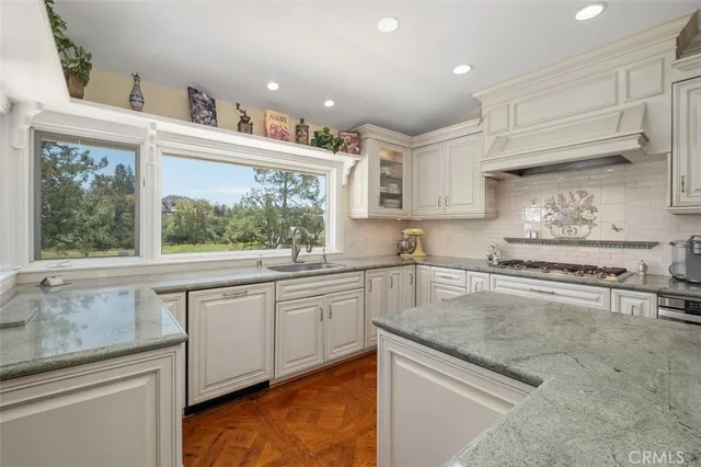 a kitchen with kitchen island granite countertop white cabinets and window