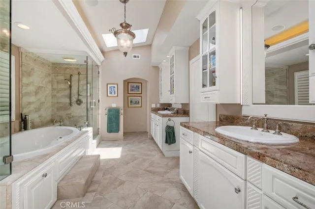 a spacious bathroom with a granite countertop tub sink a mirror a shower and vanity