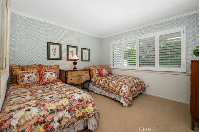 a bedroom with two beds and a window with outer view