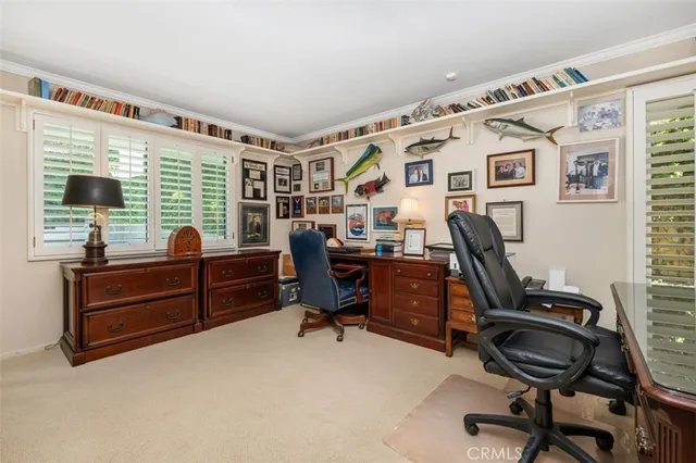 a view of a workspace with furniture and a window