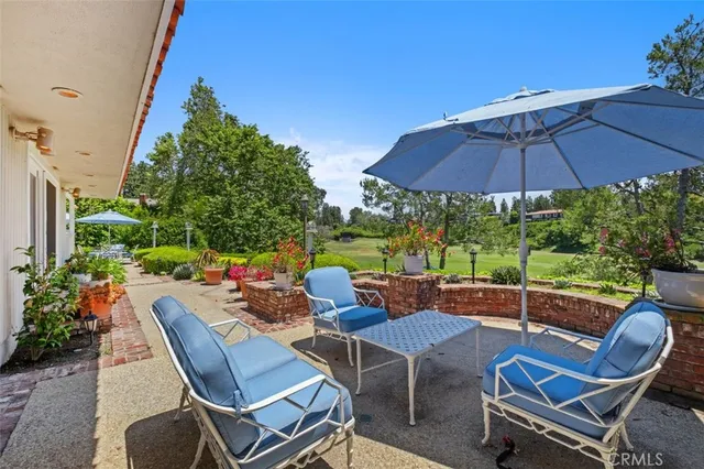 a view of a patio with a table and chairs under an umbrella
