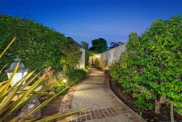 a view of a patio with table and chairs potted plants and large tree