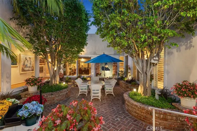 a view of a table and chairs under an umbrella in the garden