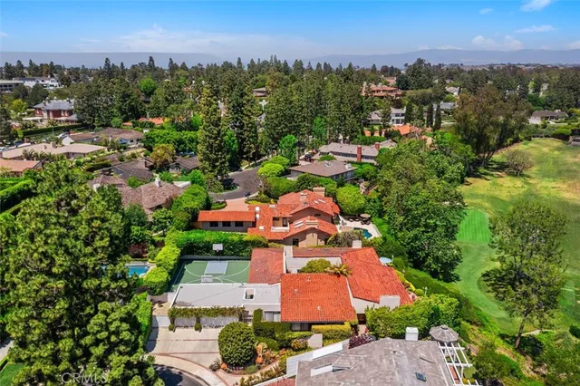 an aerial view of residential houses with outdoor space and trees