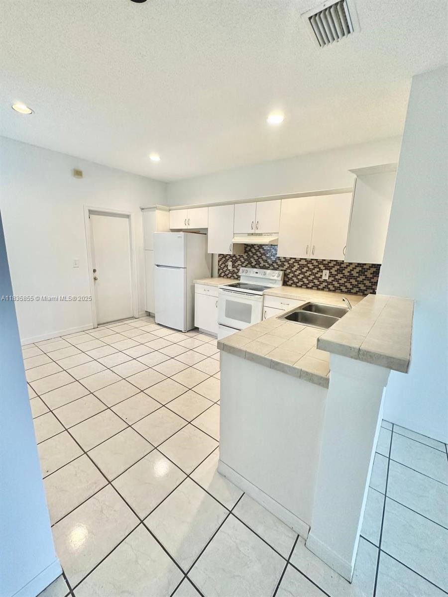 The Ridges Weston, FL 33331 - Photo 16 of 54 a kitchen with a stove top oven and cabinets
